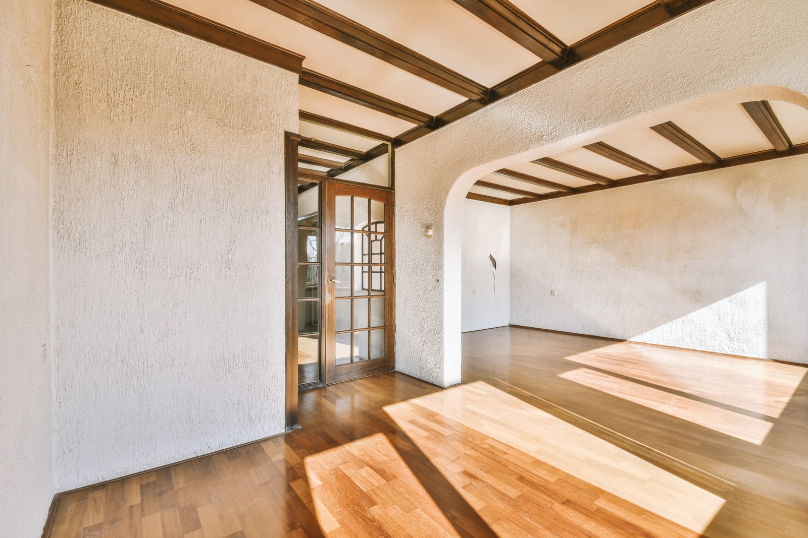 Interior of an empty room with wooden floor and white walls