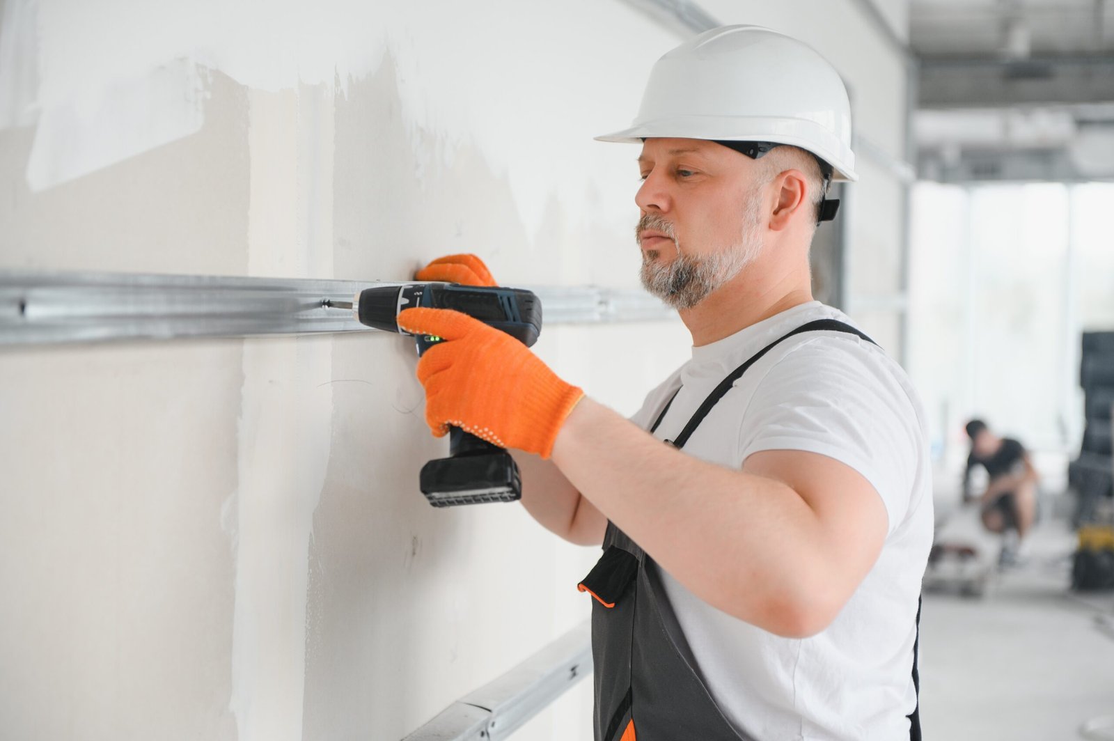 Worker install a plasterboard wall.
